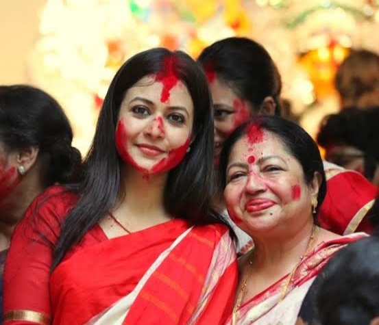Koel Mallick in a traditional white saree with a red border at the Mallik Bari Sindoor Khela during Vijayadashami 2026.